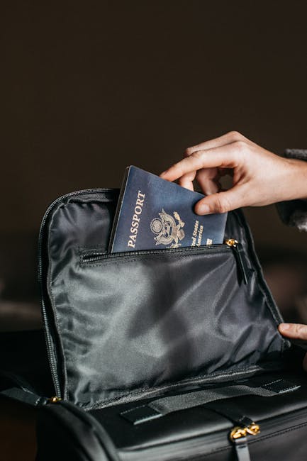 Close-up of a person placing a passport into a leather bag, ready for travel.